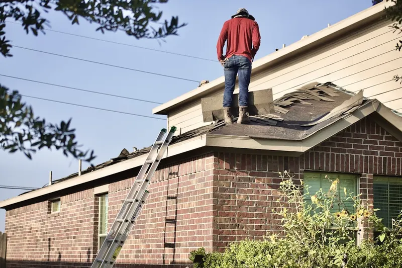 Professional roofer working on a residential roof in Emerald Forest